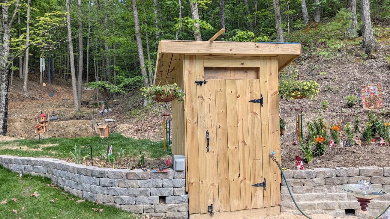 The finished well house with gnome garden behind it